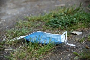 Discarded mask in middle of grass for Reduce Single Use Plastic article