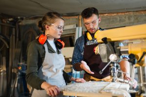 A-Level results Female apprentice being taught at drill press
