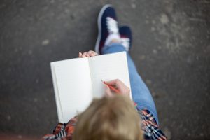 Student girl writing with a pencil in a notebook. View over the head. For A Bad Relationship With My Mum article