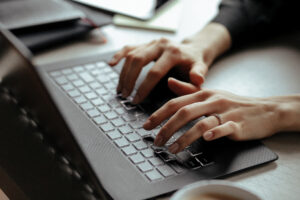 Hands typing on laptop keyboard