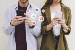 Two people on their phones on social media, liking etc. For fake news blog