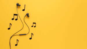 pair of bud earphones on yellow background with musical notes around them for remote learning tips article