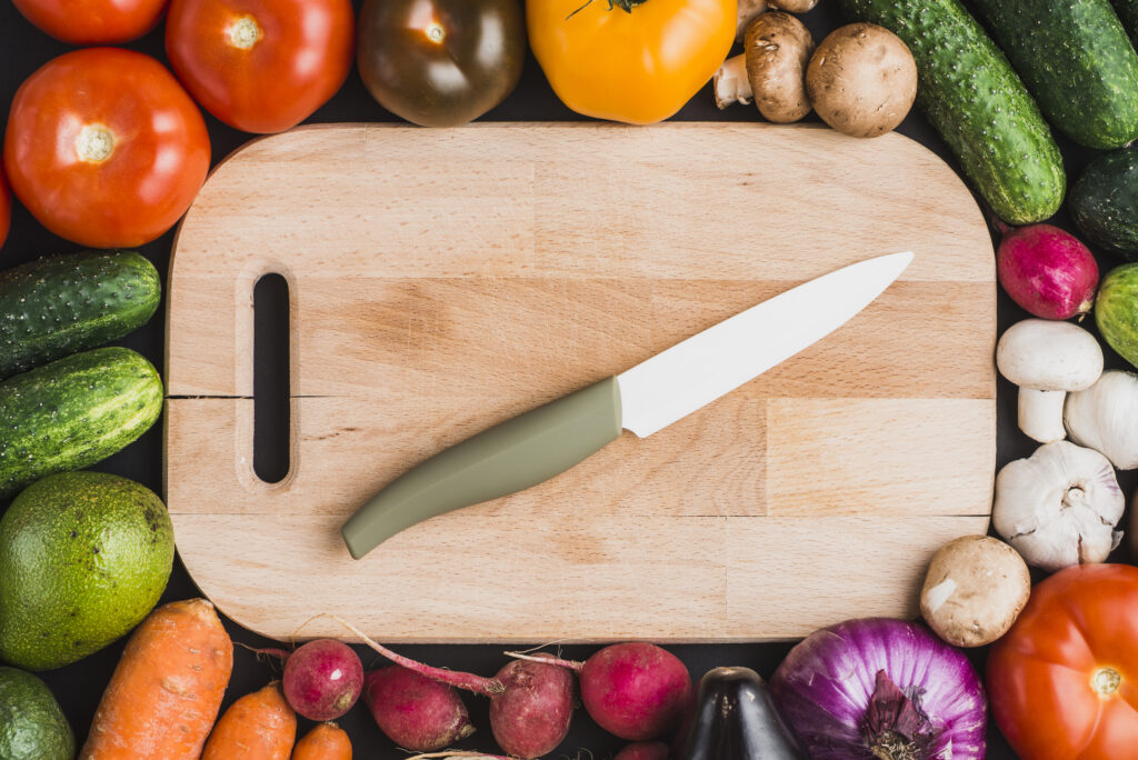 Chopping board, knife and array of vegetables