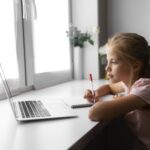 Young gorl sat in front of laptop