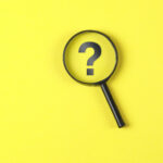 magnifying glass, question mark on yellow background for How To Cope With Distressing Things in the News blog