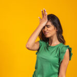 Beautiful woman forgotten and confused on yellow background
