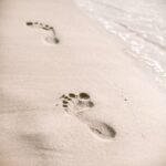 Soft focus and tone of footprints on the tropical beach sand with coast line. 