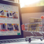 Shopping online concept - Parcel or Paper cartons with a shopping cart logo in a trolley on a laptop keyboard. Shopping service on The online web. offers home delivery