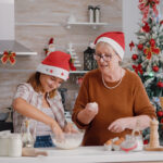 Family wearing xmas hat enjoying cooking together making delicious dessert