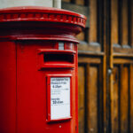 Iconic red British mailbox in a city