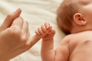 Baby holding an adult finger