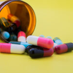 Medical pills spilling out of a toppled from pill bottle