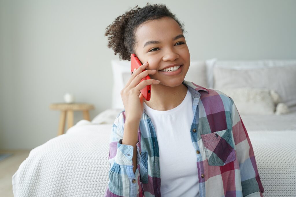 Smiling teen girl making phone call