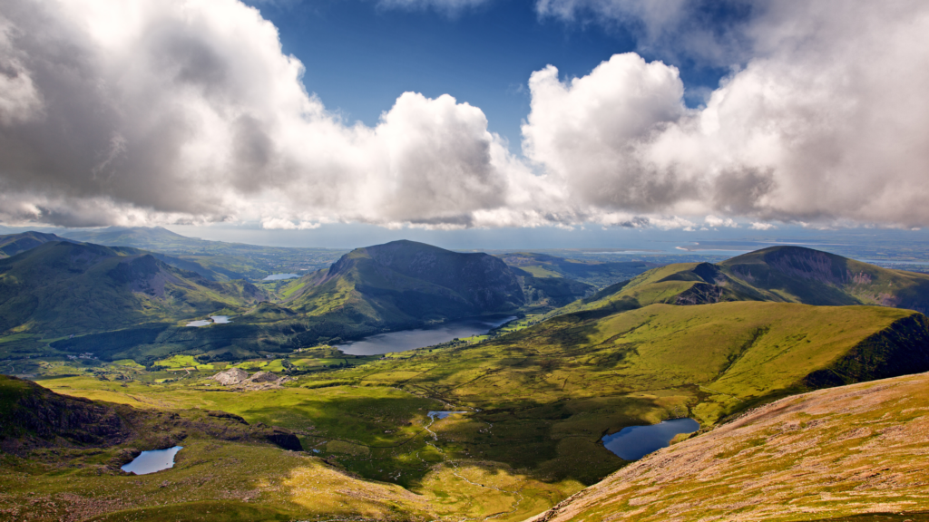 Mynyddoedd gwyrdd gydag afonydd a chymylau gwyn yn yr awyr - Parc Cenedlaethol Eryri