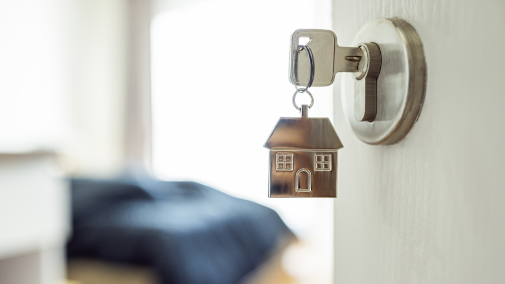 Keys in an open door, leading to a tidy bedroom