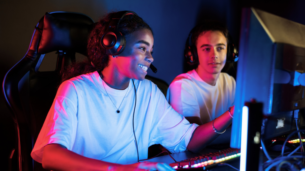 Two teens gaming together in a LED lit room
