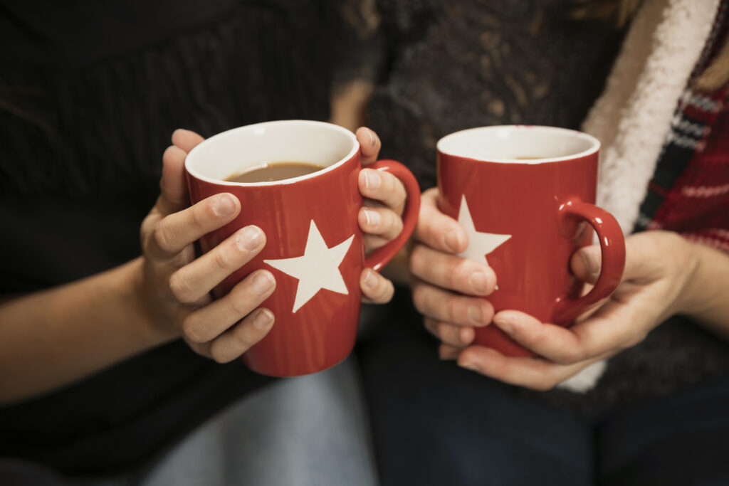 close up photo of two people holding red mugs