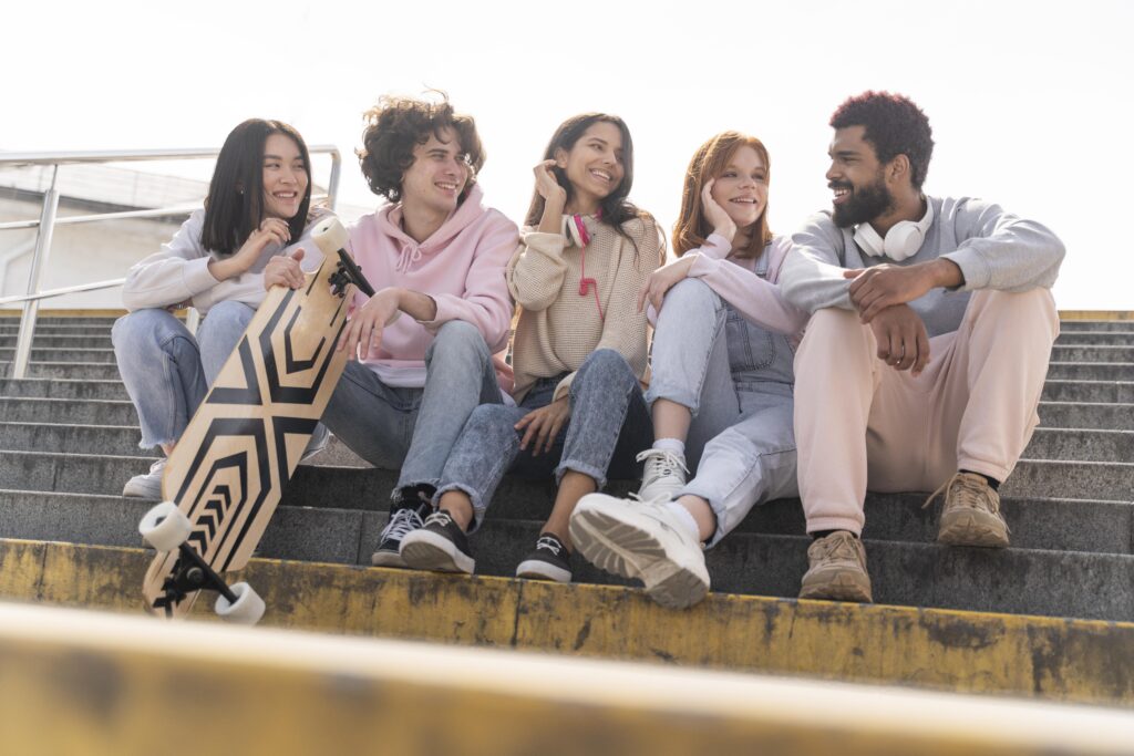 Group of friends smiling and sitting together outside. Sexist banter blog. 