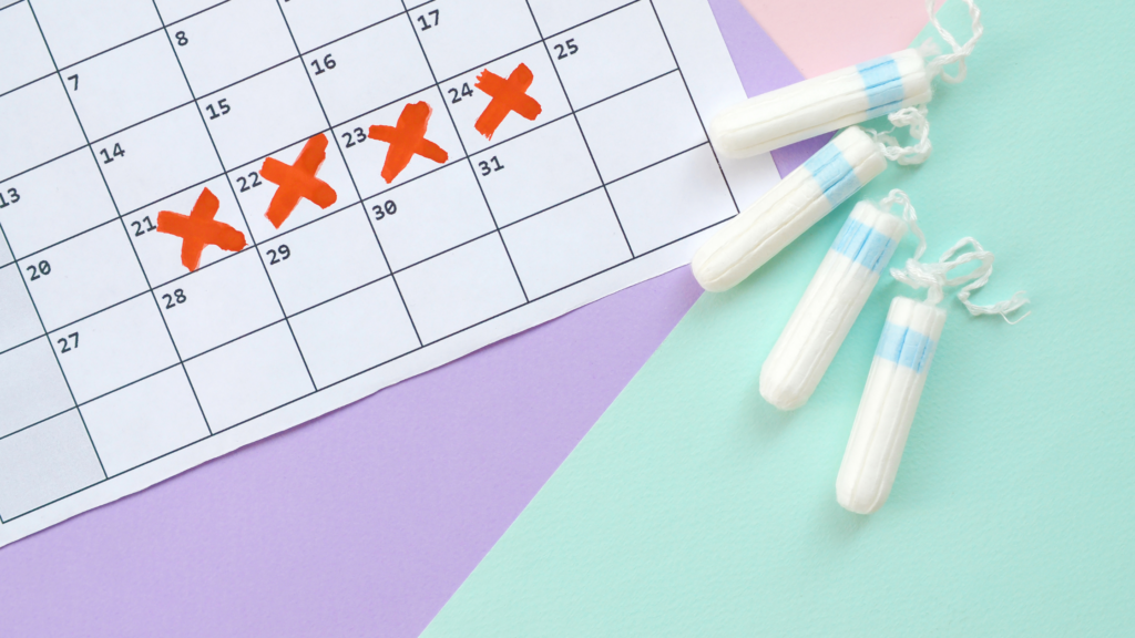 A calendar being marked off when on periods, with tampons next to it