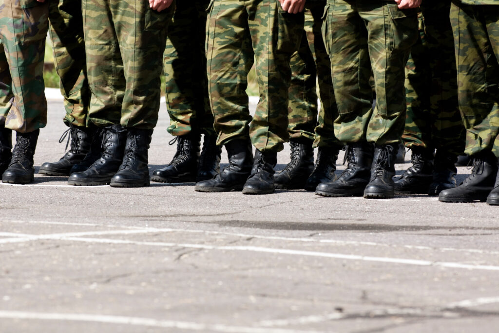 Picture of a line of military soldiers with black boots and khaki trousers