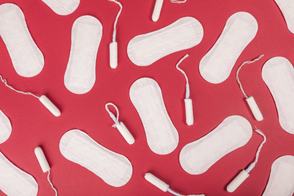 A top view picture of sanitary towels and tampons on a red background