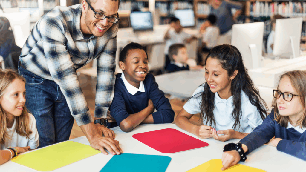 Teacher talking to a group of primary school students around a table in a classroom