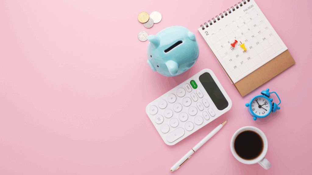Purple tablecloth with piggy bank, clock, calculator, pen, calendar and a coffee cup on it