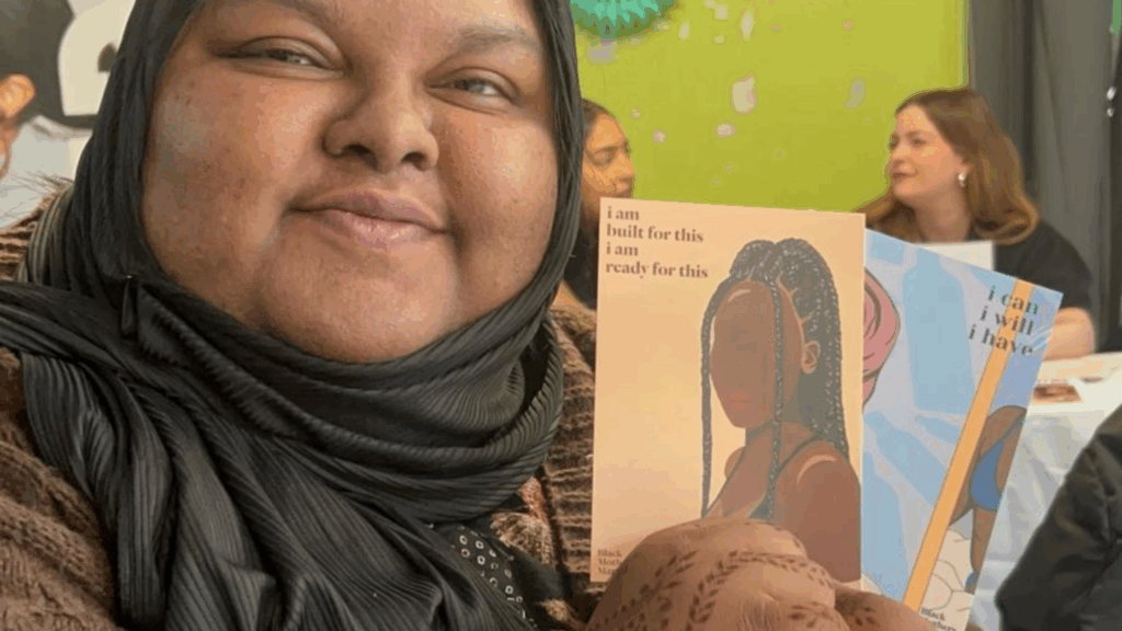 Athika, a young activist part of the Love Your Period campaign, showing some cards depicting women's strength