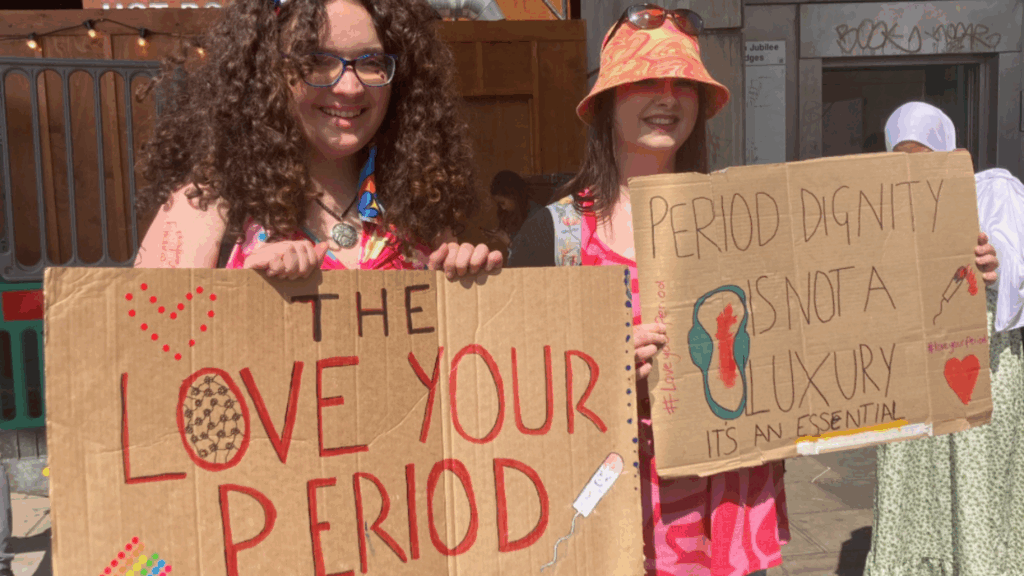Placards held by members of the Love Your Period Campaign.