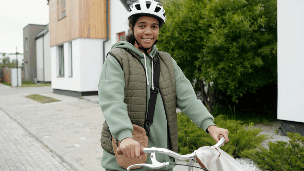 Teen girl in care rides a bike with a helmet on